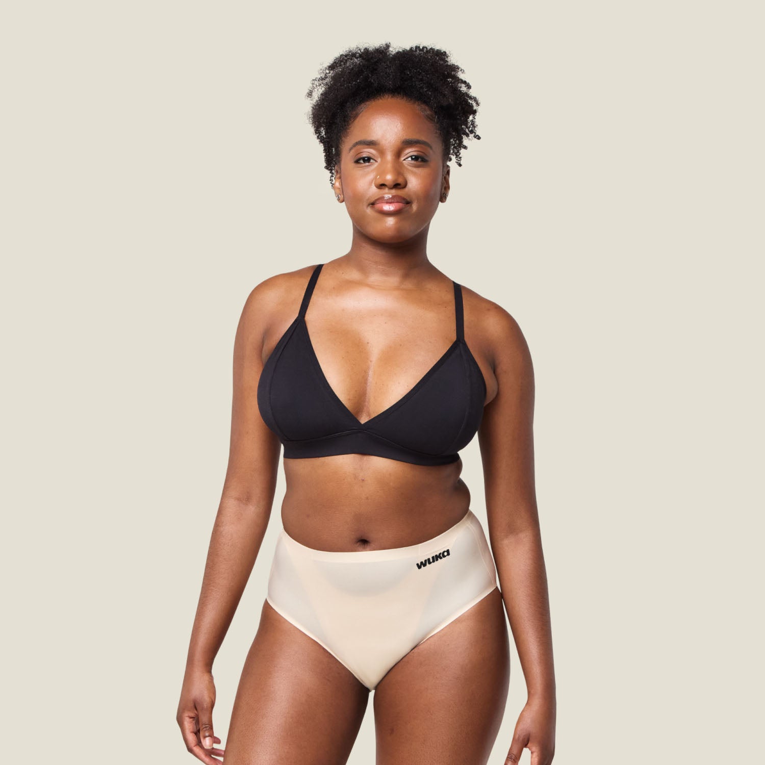 Model wearing WUKA Stretch Seamless Midi Brief Light Flow in Light Nude, showcasing full front view of high-waisted period underwear.