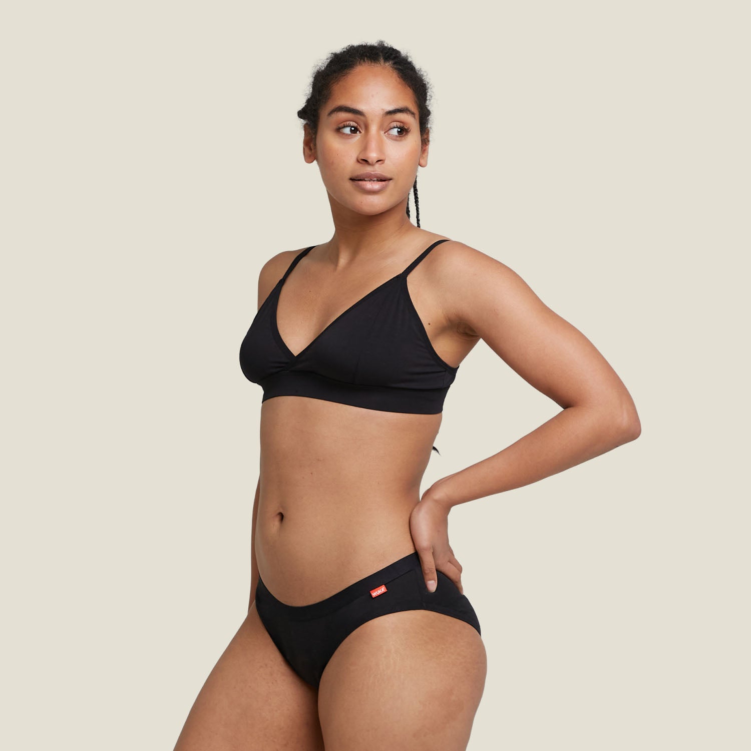 Model wearing WUKA Basics™ Hipster medium flow period underwear and matching bralette, posing confidently with hands on hips.