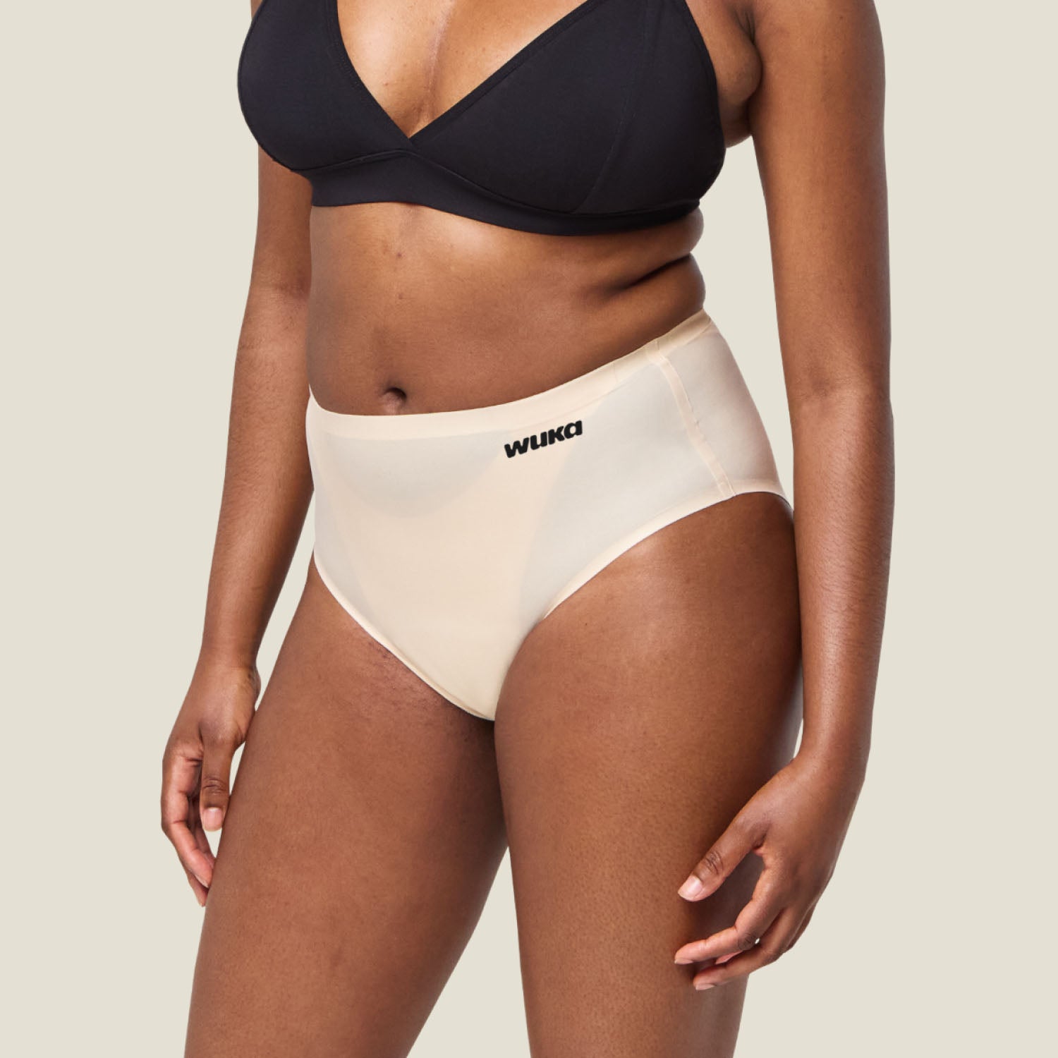 Side profile of model wearing WUKA Stretch Seamless Midi Brief Light Flow in Light Nude, showing flattering fit and comfort.